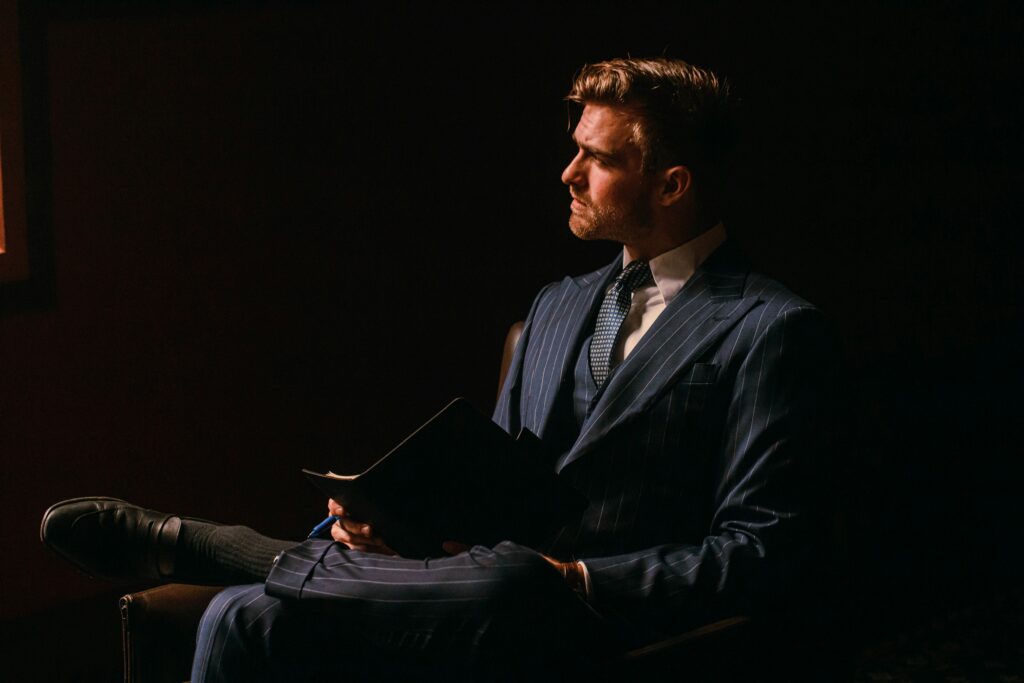 well-dressed confident man studying book demonstrating self-respect and personal development habits
